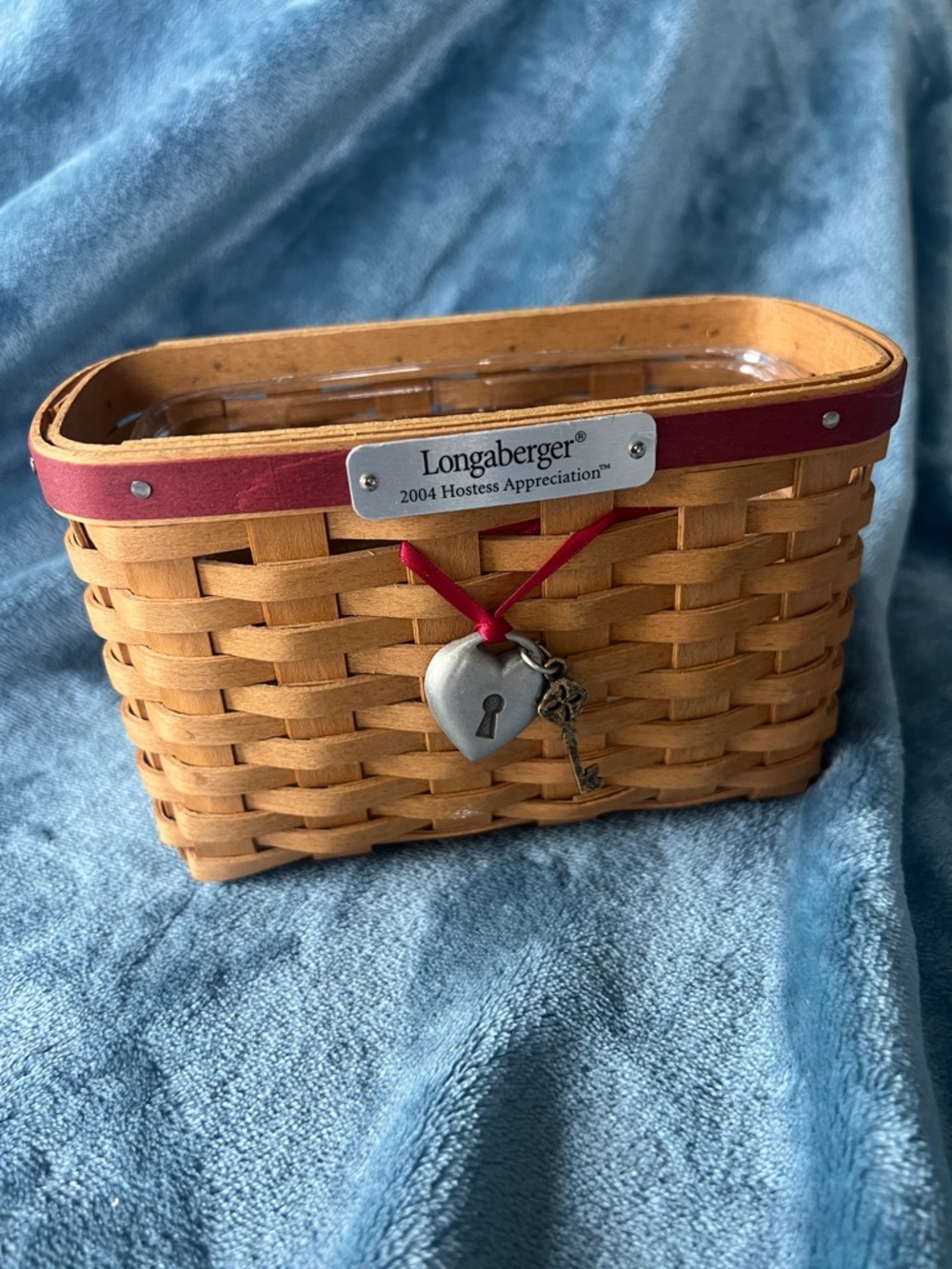 Longaberger woven basket with red trim and metal charms